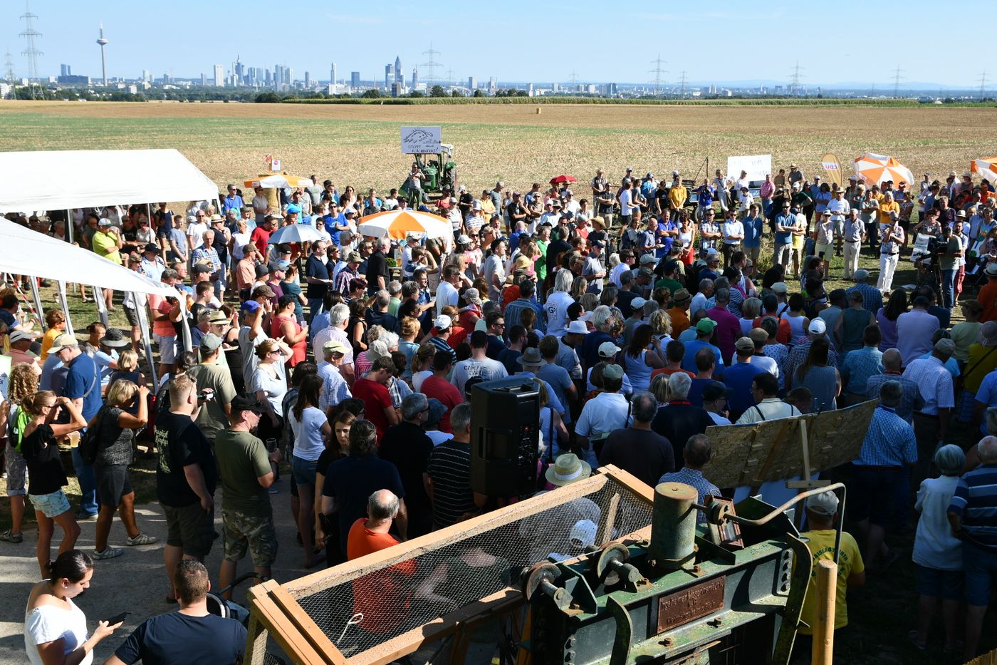 Große Menschenmenge auf einem Feld mit der Frankfurter Skyline im Hintergrund