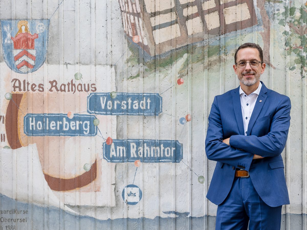 Jens Uhlig vor dem Wandbild mit Oberurseler Stadtwappen, Altem Rathaus und den Straßennamen der Altstadt